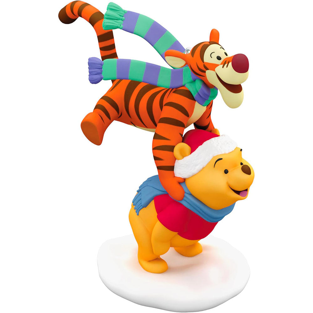 Front view of the ornament showing Tigger leaping gleefully over Pooh on snowy base